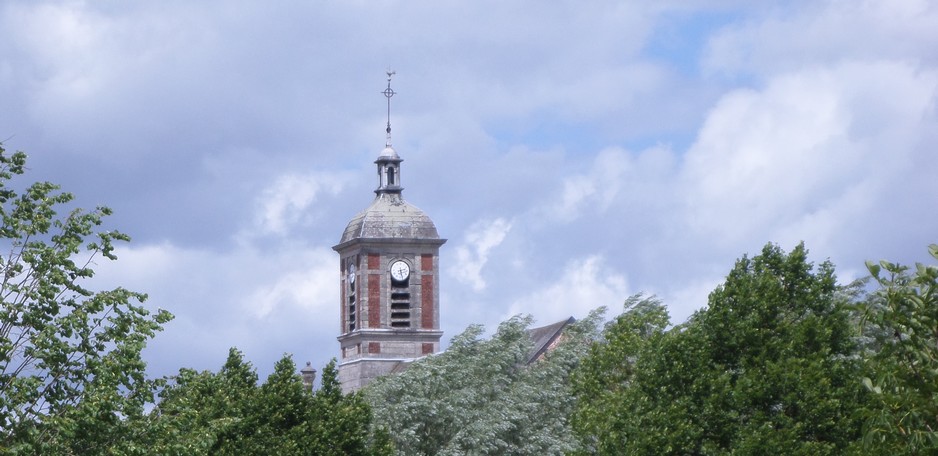 Le clocher de l'église de Bousies vu du parc rural.