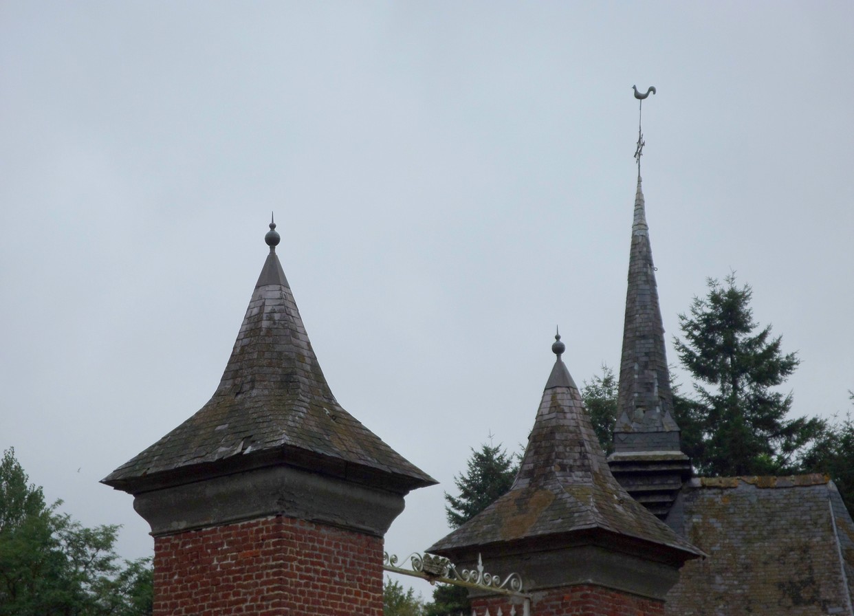 Le clocher de la chapelle et les toitures pyramidales des piliers de l'entrée du château de Rametz.